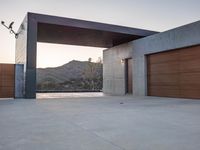 an outside garage door with mountains in the background and a couple of lights above it