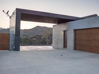 an outside garage door with mountains in the background and a couple of lights above it