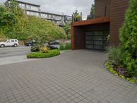 two cars parked in front of a building near a parking lot and green trees and bushes