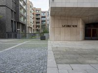 a street with a building, sidewalk and large sign on it's side that says lutzen