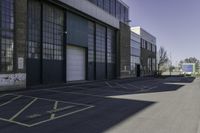 a warehouse yard has yellow lines and parking spaces for people to walk down the side of it