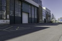 a warehouse yard has yellow lines and parking spaces for people to walk down the side of it