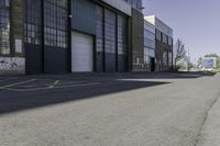 a warehouse yard has yellow lines and parking spaces for people to walk down the side of it