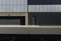 the empty parking lot near two garages in front of an office building that is empty