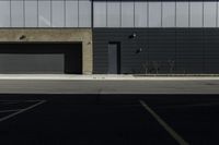 the empty parking lot near two garages in front of an office building that is empty