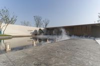 a building on the edge of an outdoor swimming area with steaming water coming out from it