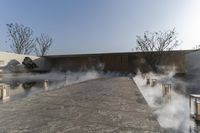 a building on the edge of an outdoor swimming area with steaming water coming out from it