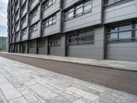 an empty, side view of a street that is next to a building with glass doors