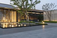 a black fire pit sits in a courtyard with light reflecting on it's patio