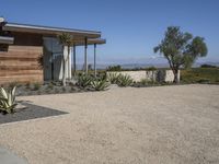 this home has concrete driveways and gravel patios to provide space for plants, bushes, and trees