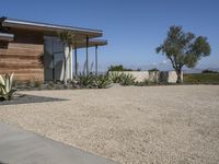 this home has concrete driveways and gravel patios to provide space for plants, bushes, and trees