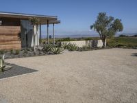 this home has concrete driveways and gravel patios to provide space for plants, bushes, and trees