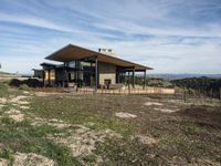 a home is on a hillside overlooking a field and the mountains in the background for a story