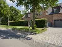 the brick and stone frontage of the home shows that there is a paved driveway in front of it