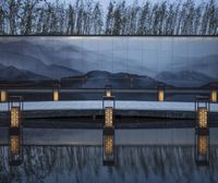 the wall with the reflection of mountains on the glass in the water is reflecting the trees