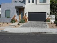 a very neat house with a small driveway in front of it and a big garage door