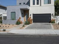 a very neat house with a small driveway in front of it and a big garage door