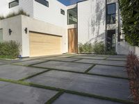 the front door is open to show the driveway and driveway of the house that sits on a stone patio