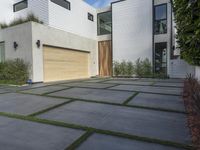 the front door is open to show the driveway and driveway of the house that sits on a stone patio