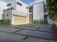 the front door is open to show the driveway and driveway of the house that sits on a stone patio