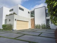 the front door is open to show the driveway and driveway of the house that sits on a stone patio