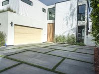 the front door is open to show the driveway and driveway of the house that sits on a stone patio