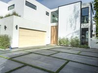 the front door is open to show the driveway and driveway of the house that sits on a stone patio