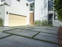 the front door is open to show the driveway and driveway of the house that sits on a stone patio