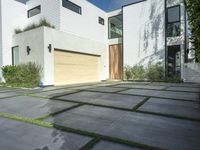 the front door is open to show the driveway and driveway of the house that sits on a stone patio