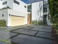 the front door is open to show the driveway and driveway of the house that sits on a stone patio