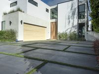 the front door is open to show the driveway and driveway of the house that sits on a stone patio