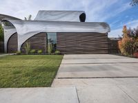 the house is all set up on a flat - faced concrete driveway, with a white perforated facade