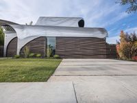 the house is all set up on a flat - faced concrete driveway, with a white perforated facade