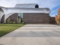 the house is all set up on a flat - faced concrete driveway, with a white perforated facade