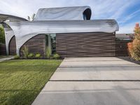 the house is all set up on a flat - faced concrete driveway, with a white perforated facade