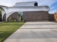 the house is all set up on a flat - faced concrete driveway, with a white perforated facade