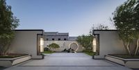 a walkway leads into an outdoor courtyard area and garden area, with a fountain sitting under the archway