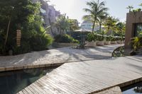 the patio area features a pool and wooden benches and umbrellas with palm trees around it