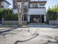 there is an empty lot outside a house that includes an entrance, and the sidewalk has some trees in it