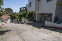 a small street with many buildings on the side and shrubs in the driveway below to the entrance