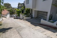 a small street with many buildings on the side and shrubs in the driveway below to the entrance