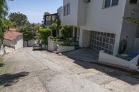 a small street with many buildings on the side and shrubs in the driveway below to the entrance