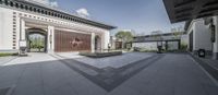 large courtyard with outdoor seating and fountain on the side walk of building of white brick building