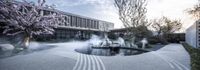 several plants are standing in the water in a courtyard area with a pool and water fountain