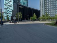 two motor scooters are parked on the road near a building with black facade