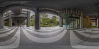 a fish eye lens image showing the outside entrance to a building with large, circular, concrete columns