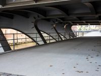 an overpass bridge with a sidewalk underneath it and a red fire hydrant next to it