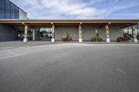 a stone building on the left side with a sidewalk to right and a parking lot area in front