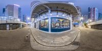 360 - angle view of an empty subway station at night with people walking under the walkway