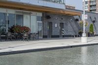 the exterior of a restaurant and water features potted flowers near a pool in front